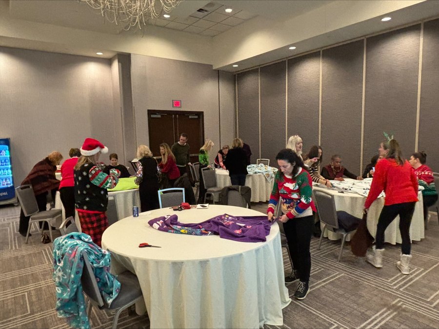 Volunteers making fleece blankets at round tables