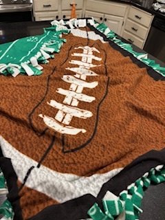 A handmade football fleece blanket with tied edges