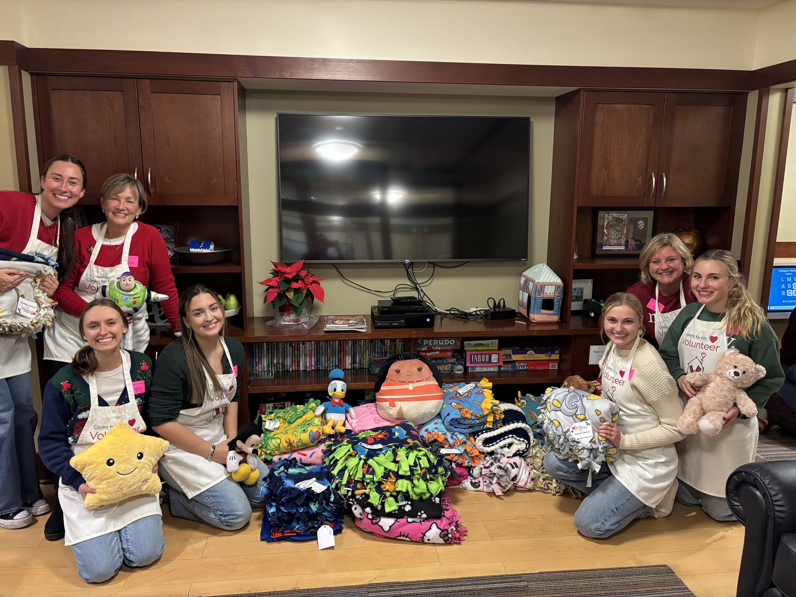 Volunteers gathered around donated blankets and stuffed animals