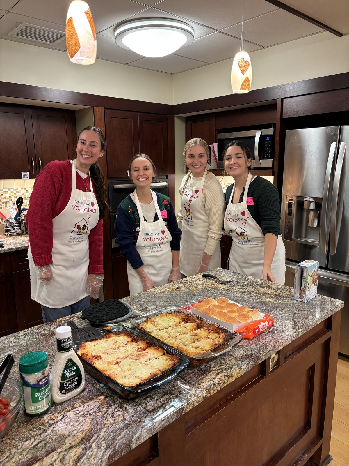 Four volunteers preparing a meal in the kitchen